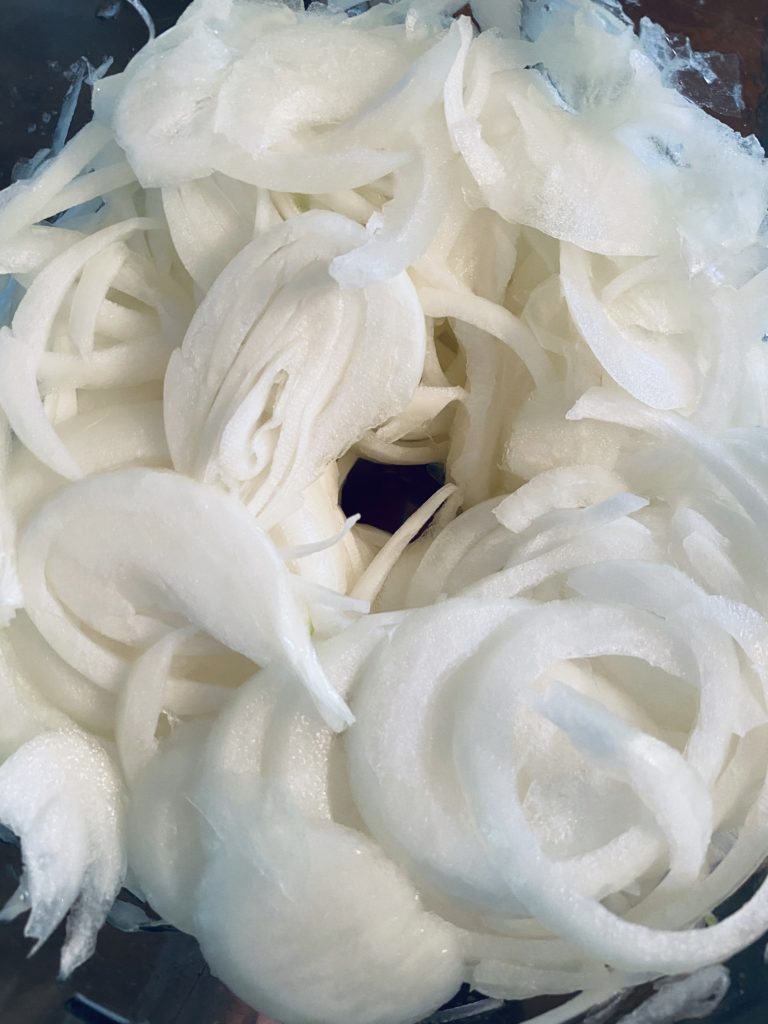 Onions slice in a food processor. 