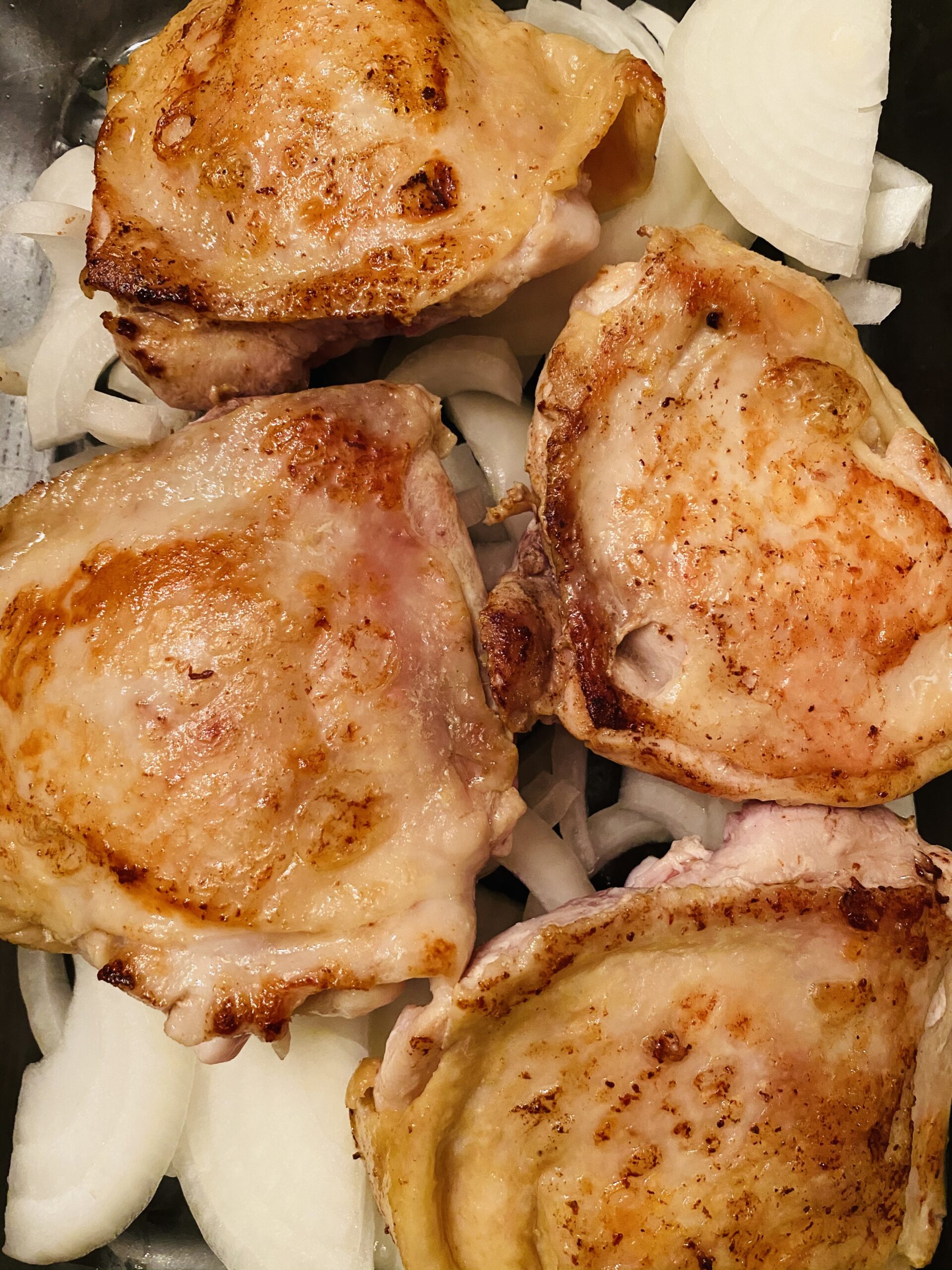 Browned chicken thighs over onions